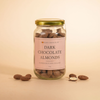 Jar of dark chocolate almonds with a pink label on a beige background