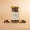 Jar of dark chocolate macadamias with an off-white label on a warm beige background