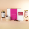 Hot chocolate gift set with a pink box labeled 'Hug in a Mug' on a beige background.