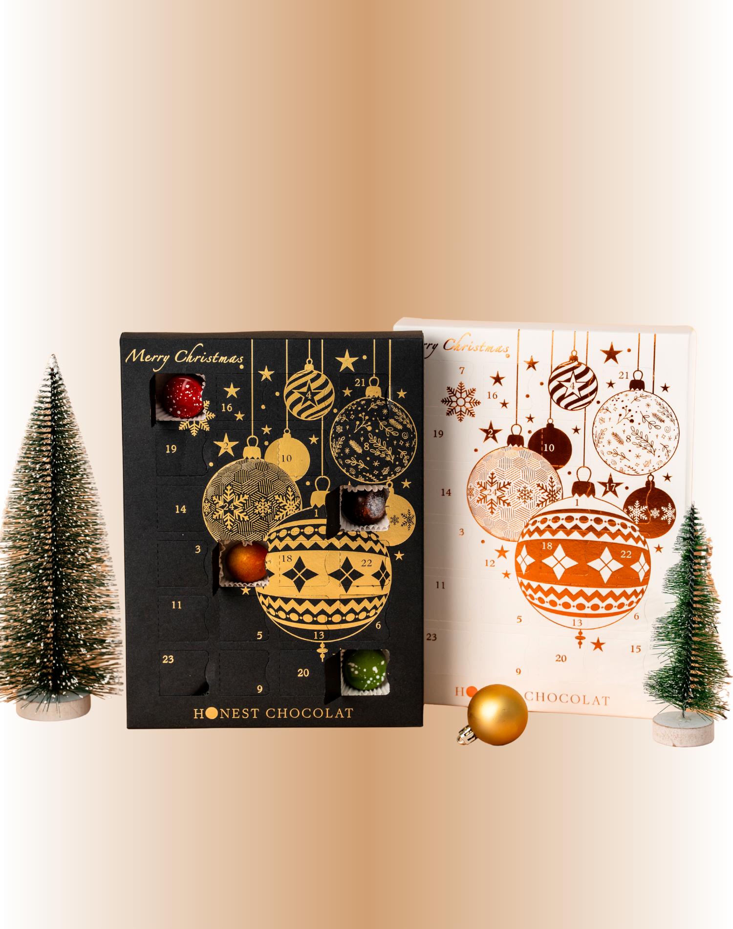 Luxury Christmas Chocolate Advent Calendars by Honest Chocolat in black & gold and white & bronze designs, displayed with festive decorative trees and ornaments, handcrafted in New Zealand.