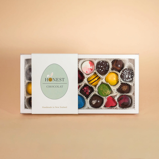 Box of colorful chocolates from Honest Chocolat on a beige background