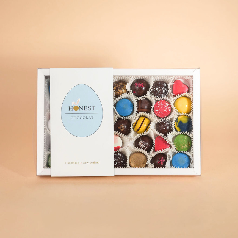 Box of assorted chocolates with 'Honest Chocolat' branding on a beige background
