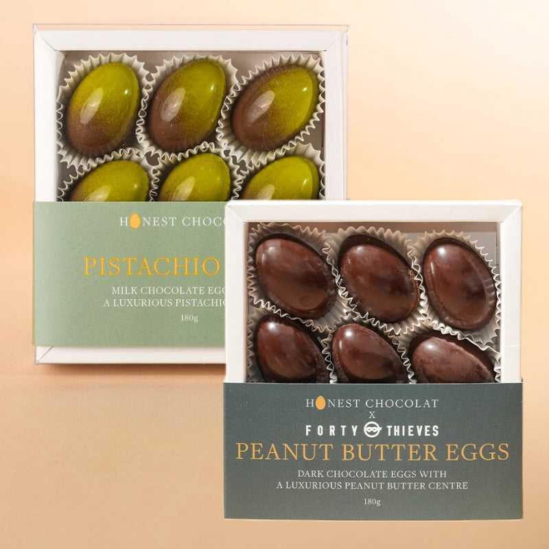 Two boxes of chocolate eggs, one pistachio and one peanut butter, on a beige background.