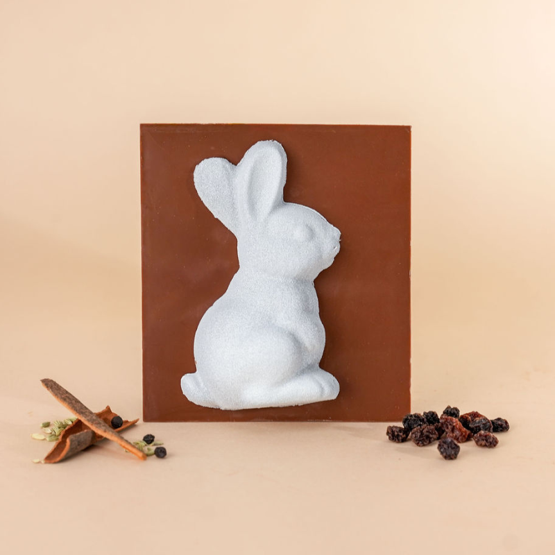 Light Blue rabbit sculpture on a brown square background with decorative elements.
