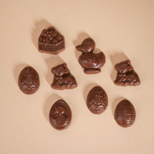 Collection of chocolate candies with various shapes on a beige background