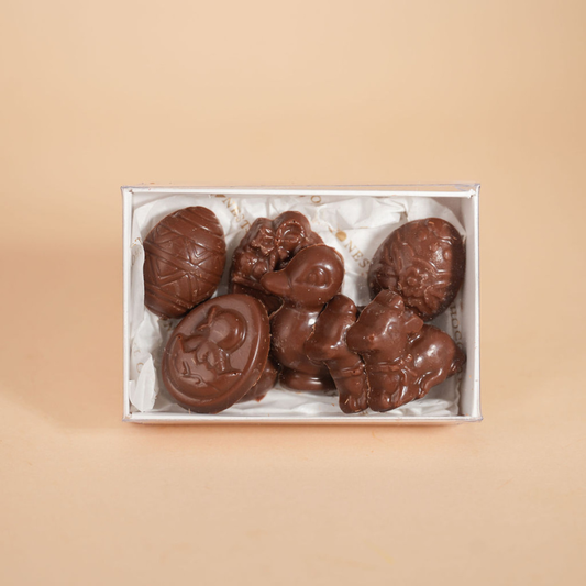 Box of chocolate figurines on a beige background