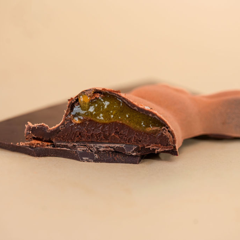 Close-up of a chocolate bunny with a passionfruit filling on a beige background