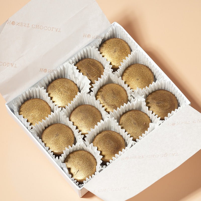 A box of twelve salted caramel chocolate bonbons with individual bonbons visible, packaged in individual white paper cups.