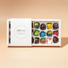 A box of assorted chocolate bonbons from Honest Chocolat, with each bonbon uniquely shaped and colored, displayed in a well-packaged and arranged box.