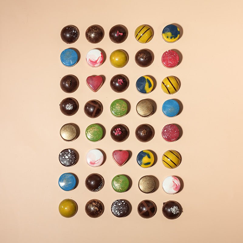 Assorted chocolate bonbons from Honest Chocolat, with each bonbon uniquely shaped and colored