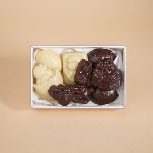 Box of assorted chocolate candies on a beige background