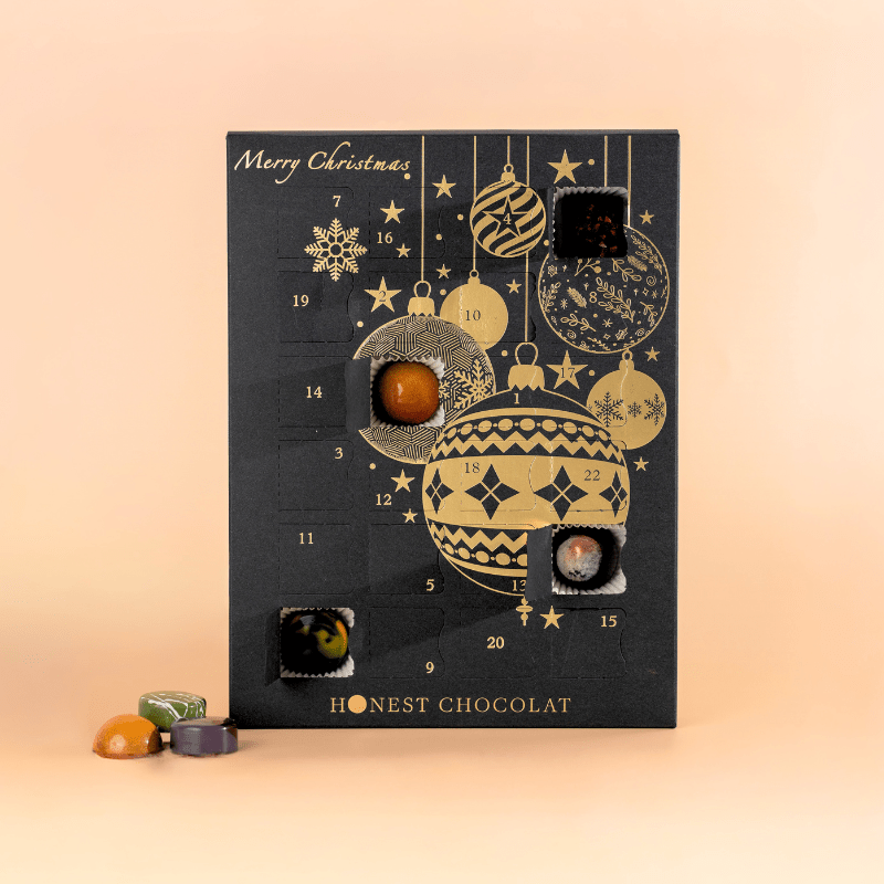 Black and gold Honest Chocolat Advent Calendar with open door showing handcrafted Christmas chocolates inside, luxury gift made in New Zealand.